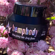 Load image into Gallery viewer, Hempbody Body Butter Black Jar PInk Flowers Lifestyle Images